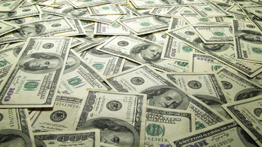 $100 bills laying flat and covering a surface